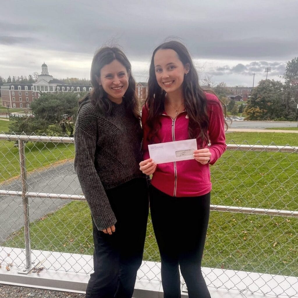 two students receiving bursary cheque